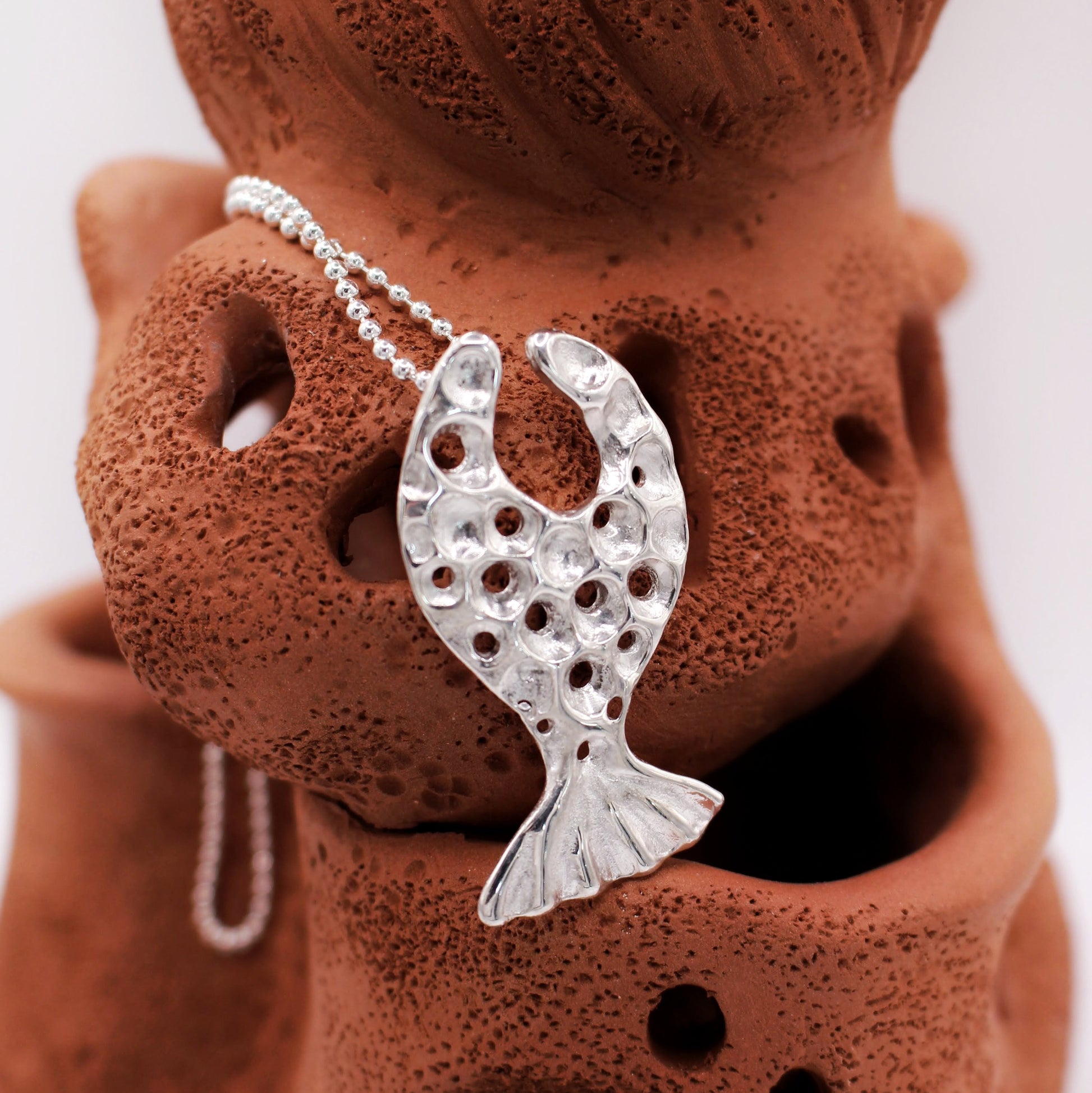 Mediterranean inspired silver pendant in organic fish design, symbolic artisan necklace