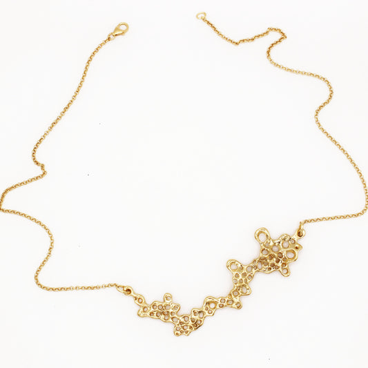 Raíz statement necklace handcrafted in sterling silver with a gold-plated finish. Mediterranean-inspired jewelry featuring a large ocean-inspired pendant with sculptural, organic forms. A bold yet elegant sustainable piece, crafted for nature and contemporary jewelry lovers by Naturalesa.