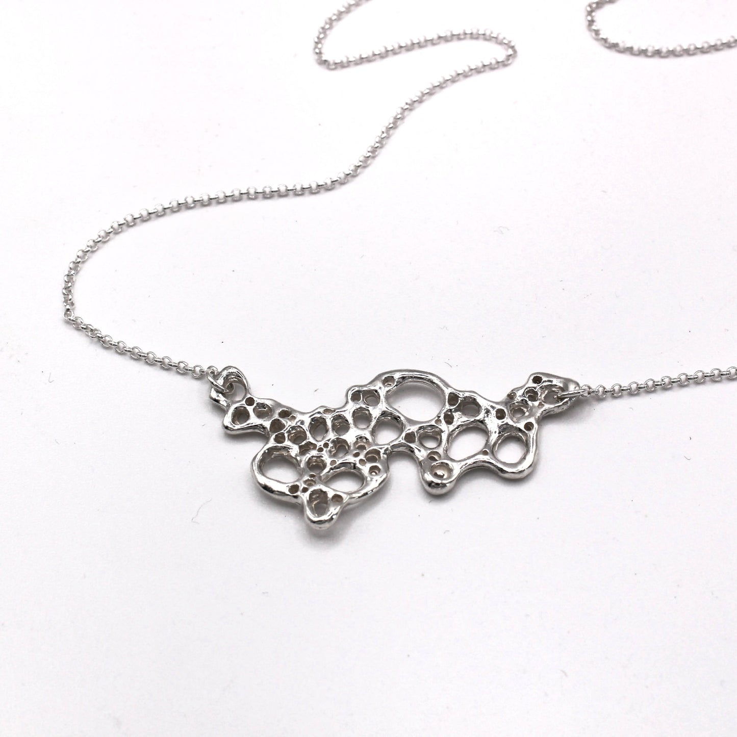 Mediterranean inspired Raíz Seafoam Pendant in silver. Symbolic jewelry capturing change, resilience, and the beauty of the present moment.