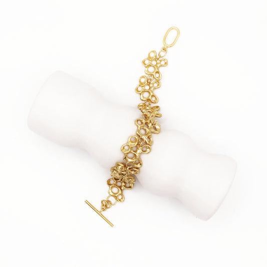 Raíz bracelet handcrafted in sterling silver with a gold-plated finish. Mediterranean-inspired jewelry formed of nine organic-shaped segments with a stylish toggle clasp. A bold yet elegant sustainable bracelet for nature and contemporary jewelry lovers, crafted by Naturalesa.