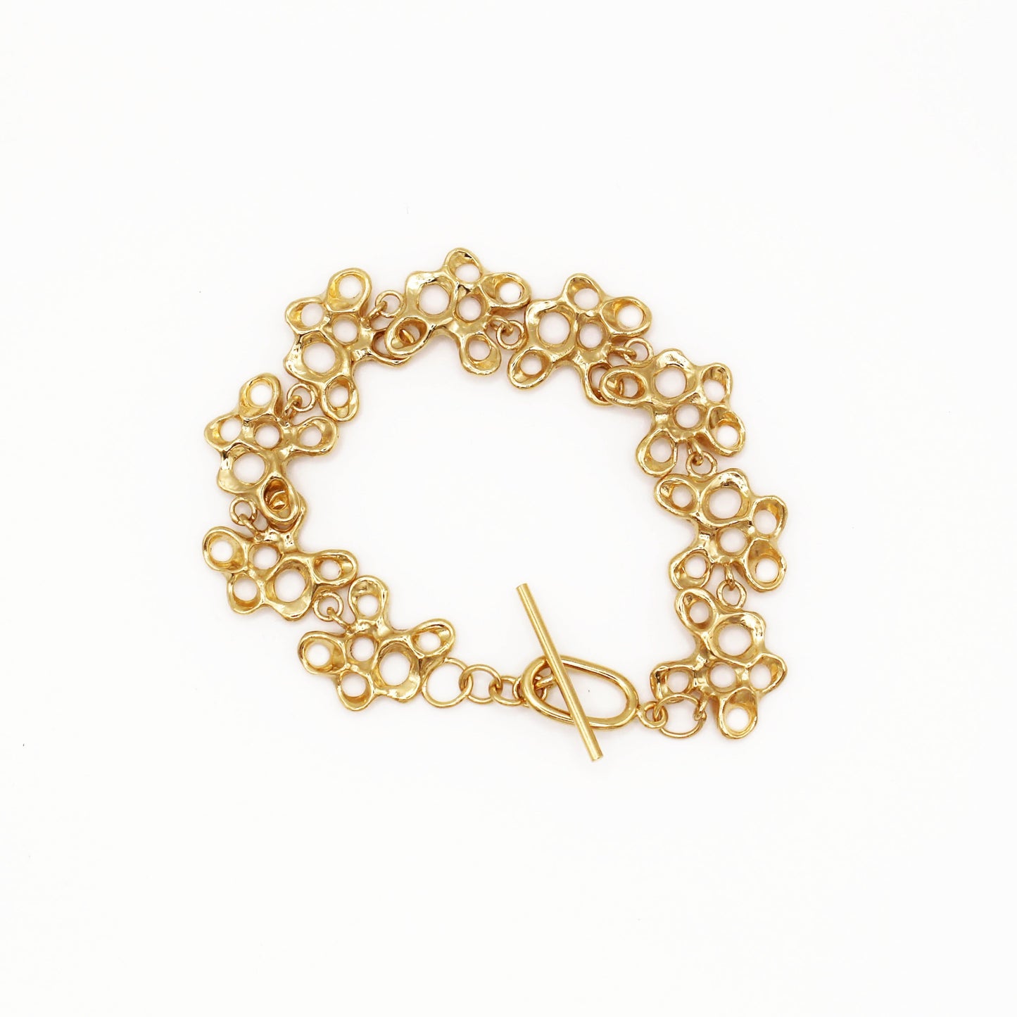 Raíz bracelet handcrafted in sterling silver with a gold-plated finish. Mediterranean-inspired jewelry formed of nine organic-shaped segments with a stylish toggle clasp. A bold yet elegant sustainable bracelet for nature and contemporary jewelry lovers, crafted by Naturalesa.