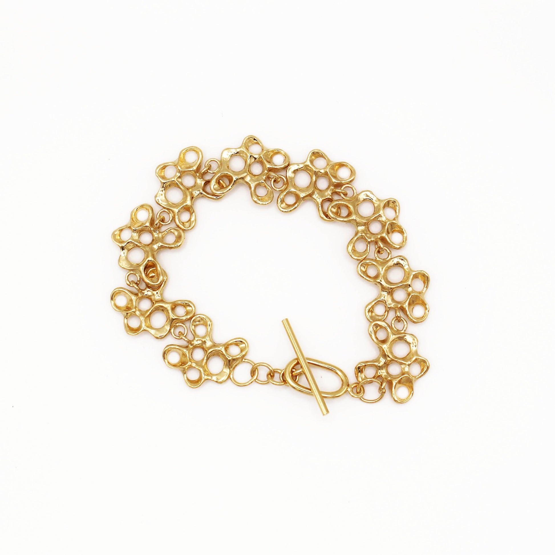 Raíz bracelet handcrafted in sterling silver with a gold-plated finish. Mediterranean-inspired jewelry formed of nine organic-shaped segments with a stylish toggle clasp. A bold yet elegant sustainable bracelet for nature and contemporary jewelry lovers, crafted by Naturalesa.