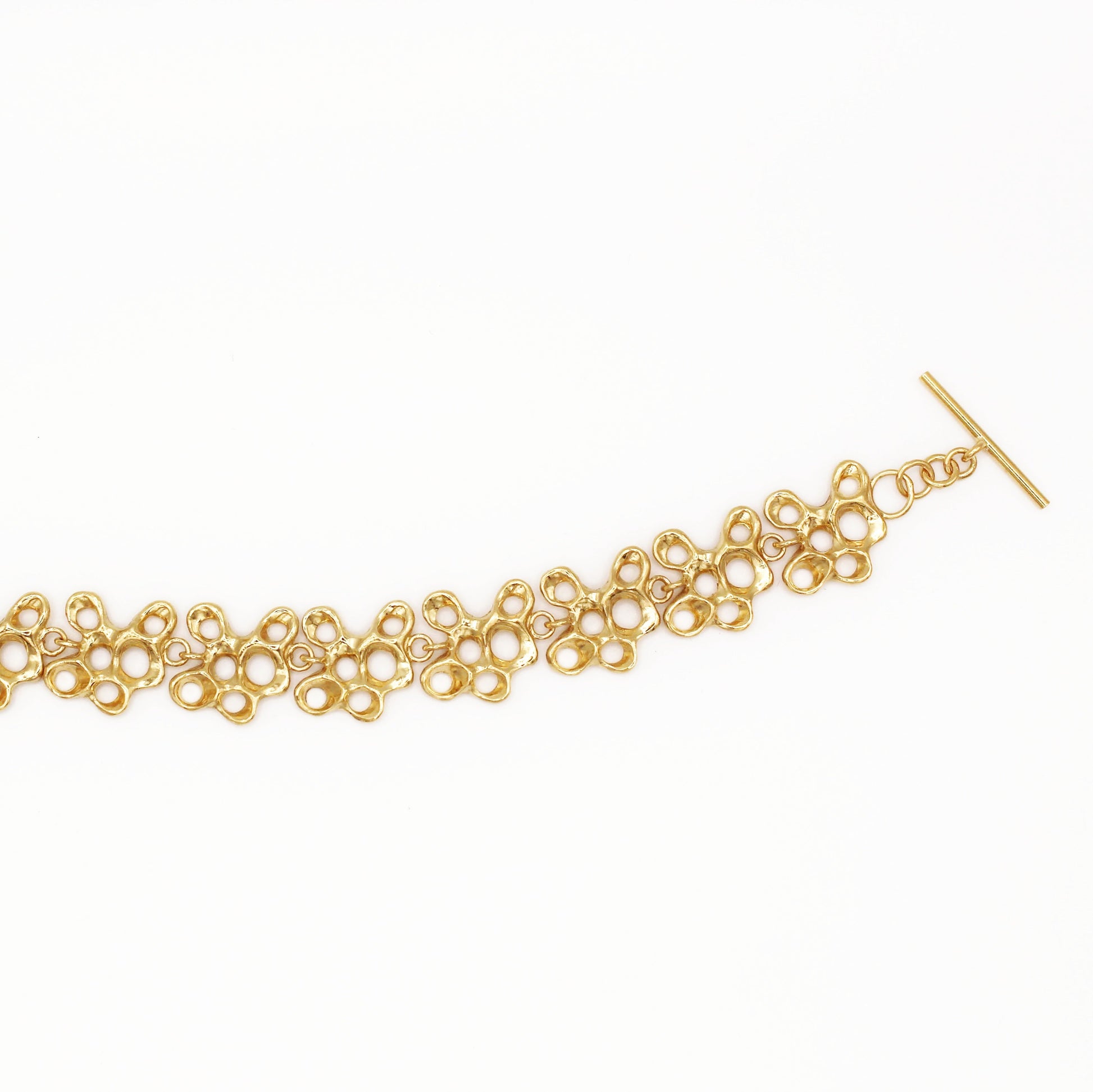 Raíz bracelet handcrafted in sterling silver with a gold-plated finish. Mediterranean-inspired jewelry formed of nine organic-shaped segments with a stylish toggle clasp. A bold yet elegant sustainable bracelet for nature and contemporary jewelry lovers, crafted by Naturalesa.