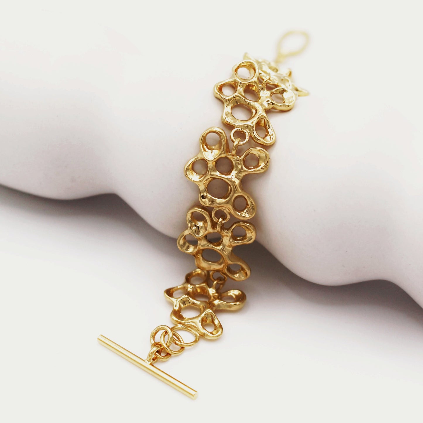 Raíz bracelet handcrafted in sterling silver with a gold-plated finish. Mediterranean-inspired jewelry formed of nine organic-shaped segments with a stylish toggle clasp. A bold yet elegant sustainable bracelet for nature and contemporary jewelry lovers, crafted by Naturalesa.