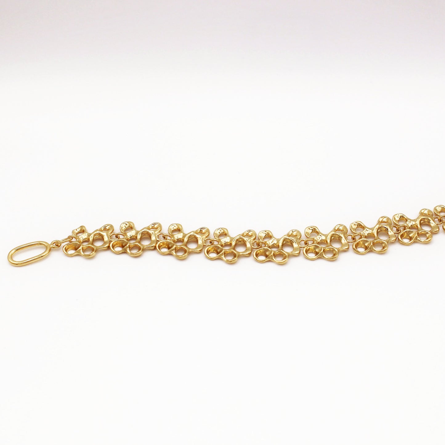Raíz bracelet handcrafted in sterling silver with a gold-plated finish. Mediterranean-inspired jewelry formed of nine organic-shaped segments with a stylish toggle clasp. A bold yet elegant sustainable bracelet for nature and contemporary jewelry lovers, crafted by Naturalesa.