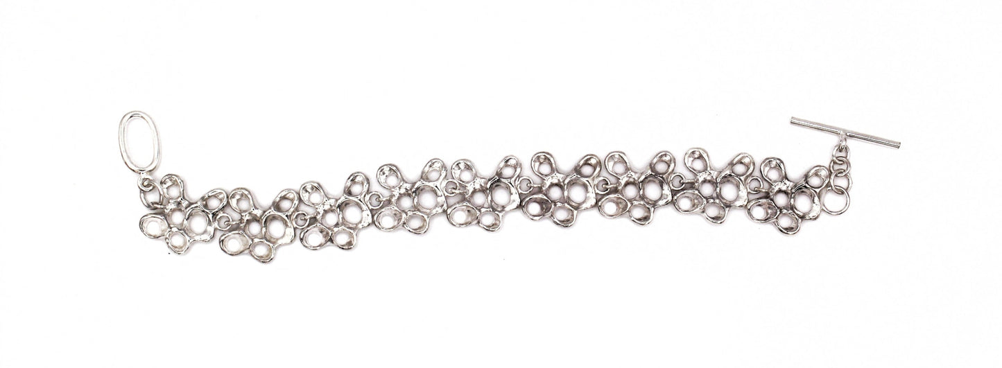 Sculptural silver bracelet with nine segments, meaningful jewelry symbolizing resilience