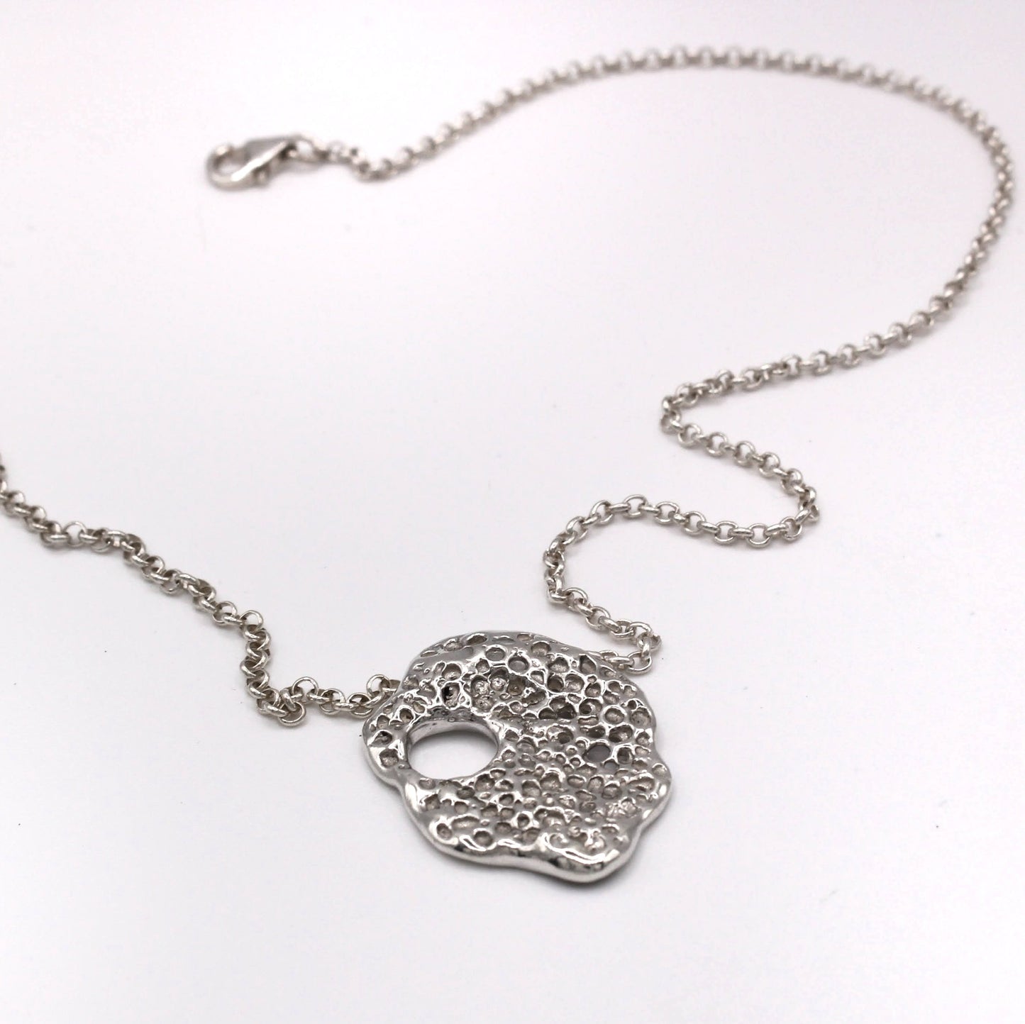 Rastro del Mar silver pendant from Piedra Collection, inspired by Mediterranean hag stones.
Colgante Rastro del Mar de plata de la Colección Piedra, inspirado en piedras agujereadas mediterráneas.