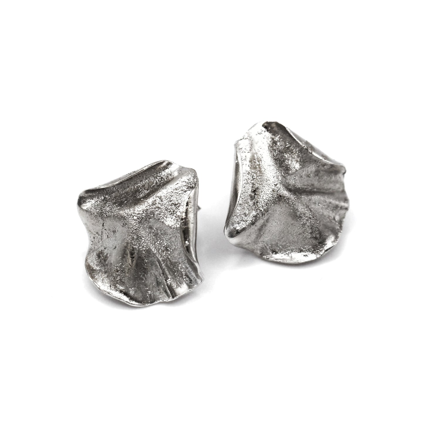 Sculptural folded silver earrings, handcrafted in recycled sterling silver using the lost wax casting technique. Mediterranean-inspired jewelry with organic, wave-like forms and a unique fused silver dust texture. Elegant and sustainable statement earrings for nature and contemporary jewelry lovers, crafted by Naturalesa.