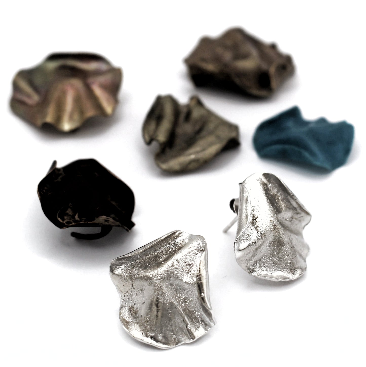 Sculptural folded silver earrings, handcrafted in recycled sterling silver using the lost wax casting technique. Mediterranean-inspired jewelry with organic, wave-like forms and a unique fused silver dust texture. Elegant and sustainable statement earrings for nature and contemporary jewelry lovers, crafted by Naturalesa.