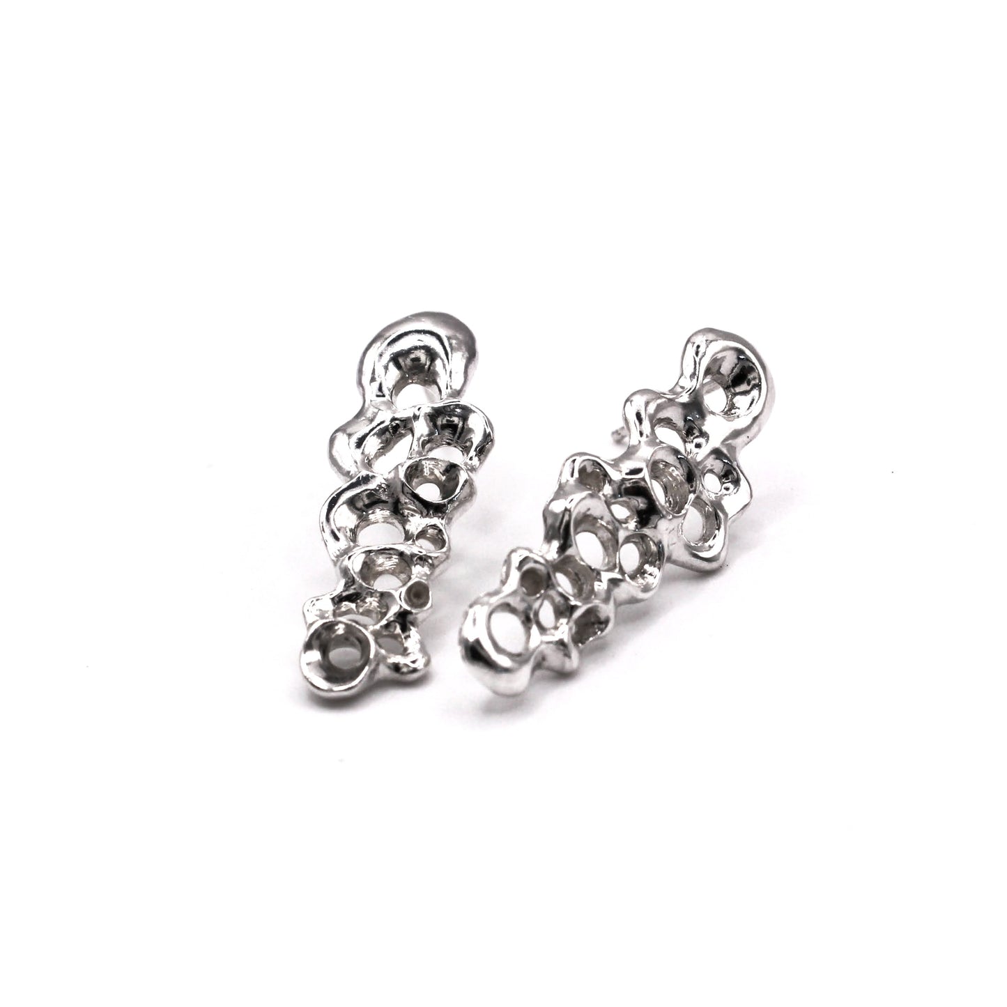 Pair of silver earrings on a white background. Pendientes largos Raíz en plata reciclada 925, pendientes asimétricos inspirados en percebes de Naturalesa Jewelry.