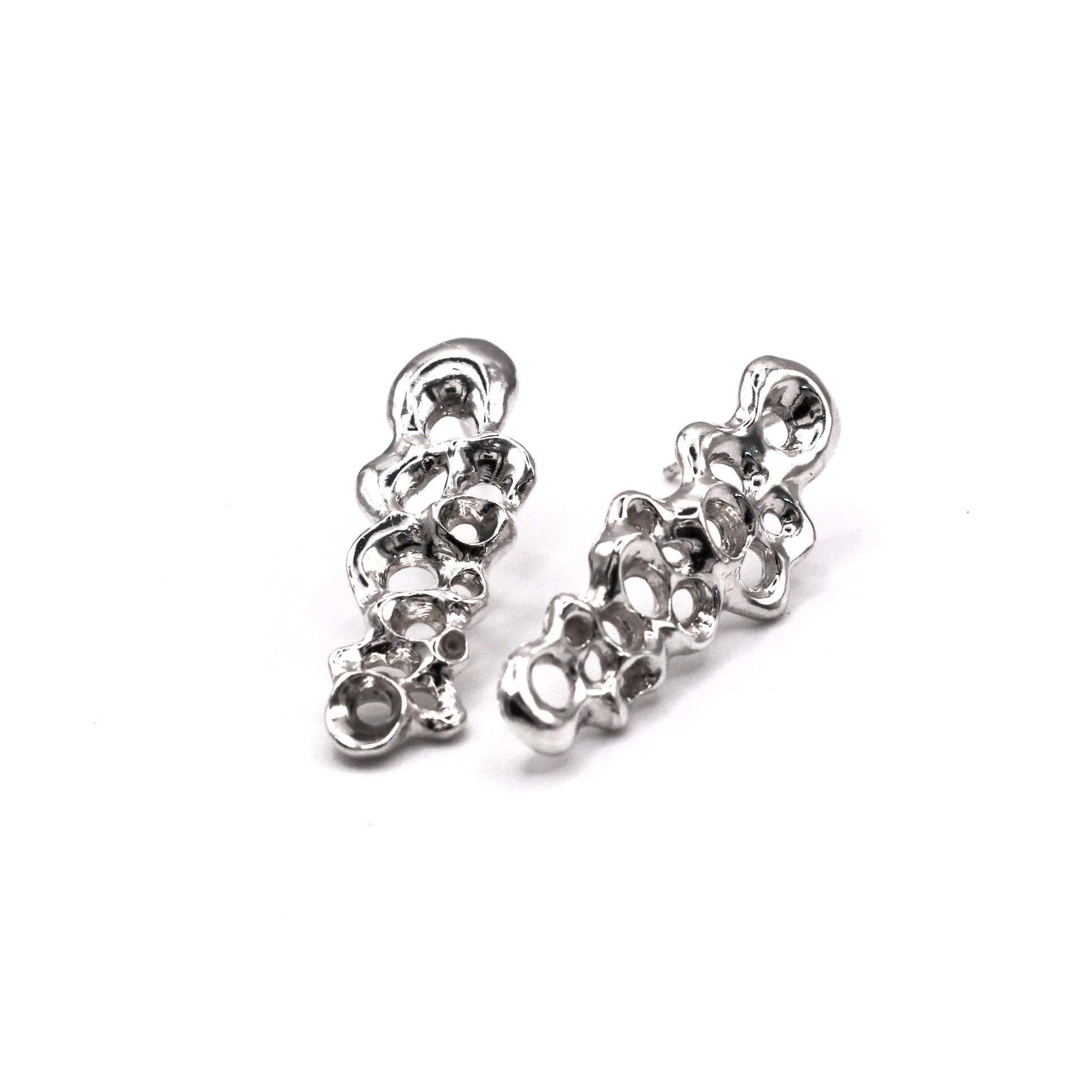 Pair of silver earrings on a white background. Pendientes largos Raíz en plata reciclada 925, pendientes asimétricos inspirados en percebes de Naturalesa Jewelry.