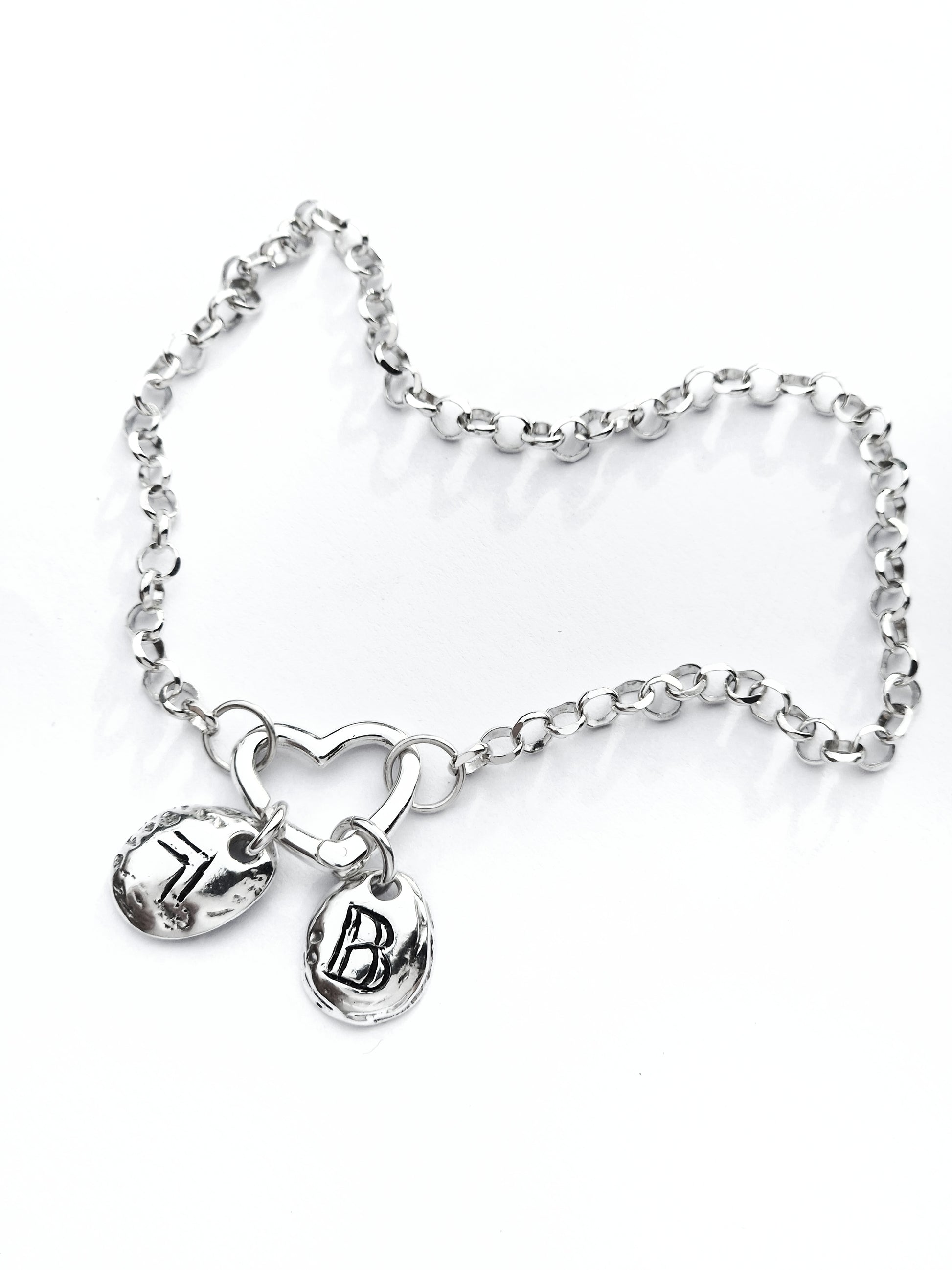 Mementos silver bracelet with heart clasp and two personalized engraved charms by Naturalesa Jewelry