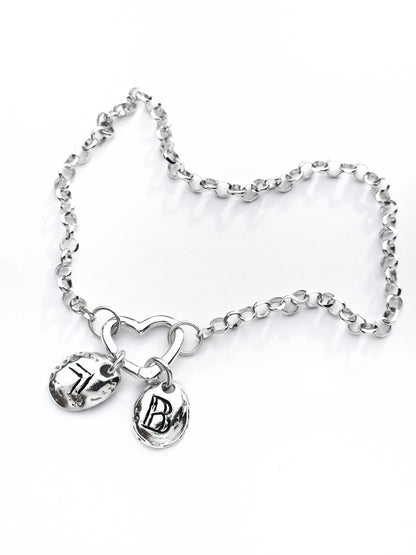Mementos silver bracelet with heart clasp and two personalized engraved charms by Naturalesa Jewelry