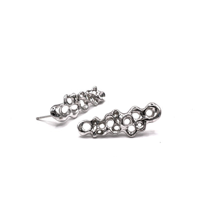 Pair of silver earrings on a white background. Long silver earrings from the Raíz Collection, handcrafted in recycled sterling silver 925, inspired by Mediterranean sea life.